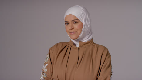 Studioporträt-Einer-Lächelnden-Muslimischen-Frau-Mit-Hijab-Vor-Schlichtem-Hintergrund-1